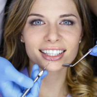 Girl with beautiful white teeth getting patient care at the doctor dentist.
