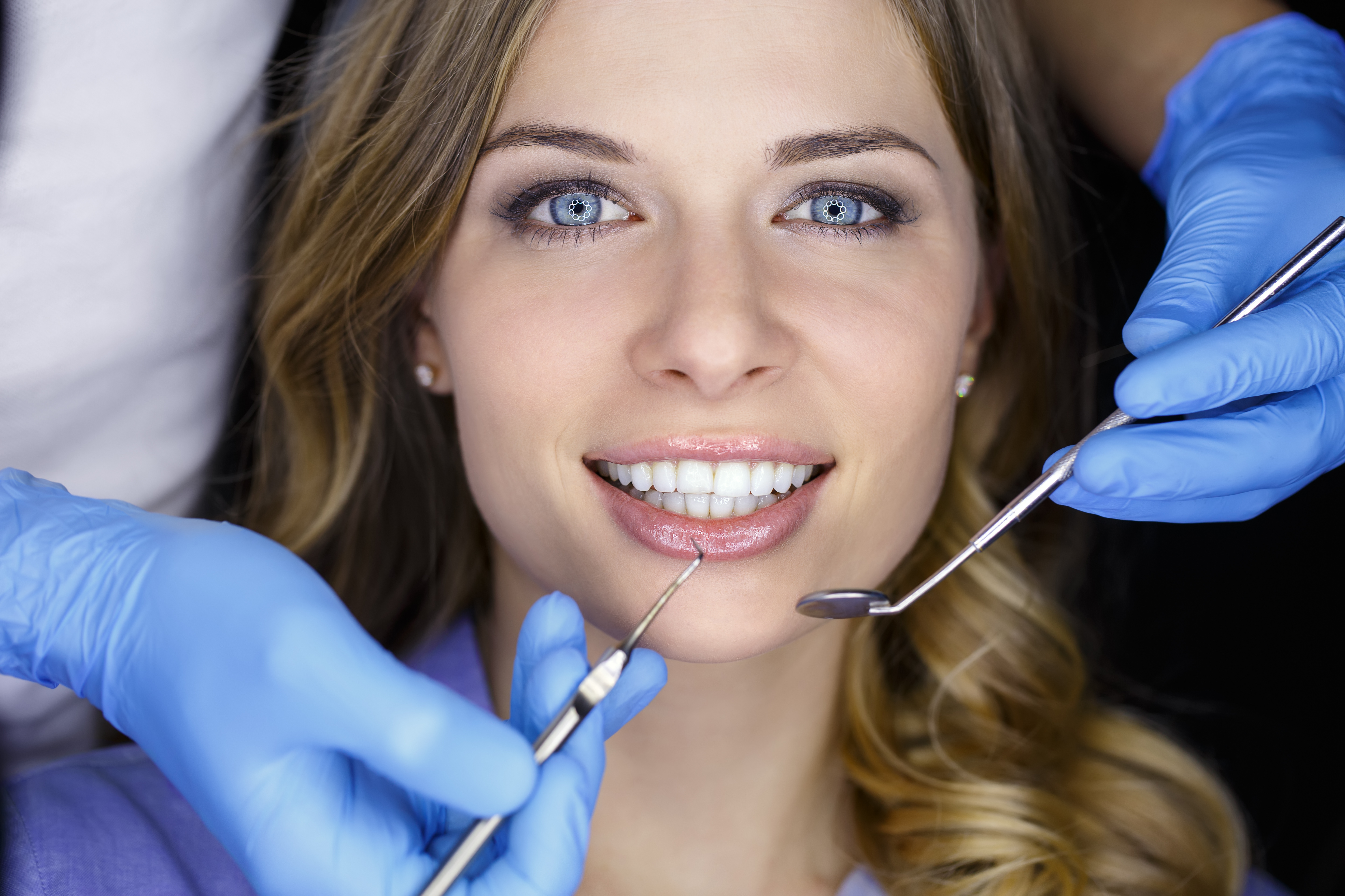 Girl with beautiful white teeth getting patient care at the doctor dentist.