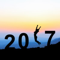 Silhouette young woman jumping over 2017 years on the hill at su