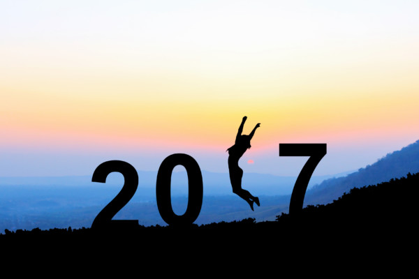 Silhouette young woman jumping over 2017 years on the hill at su