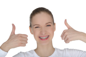 Smiling happy girl with braces isolated on white