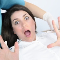 a young girl is scared at dentist visit