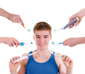 young man who has many tooth brushes being offered to him at the same time